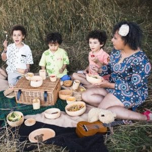 three children and their mum having a picnic in a meadow