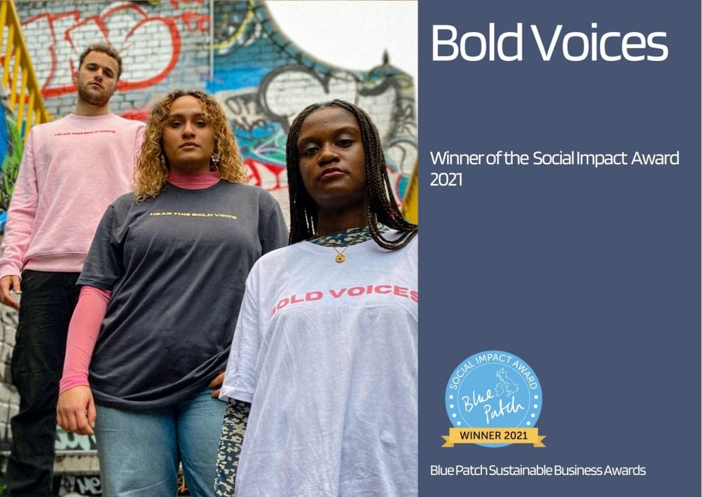 three youths posing in Bold Voices tee-shirts, in front of a graffiti wall, representing an award winning social impact organisation