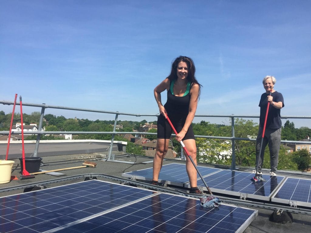Margy Newens mopping solar panels on the roof of St Christopher's hospice, London.