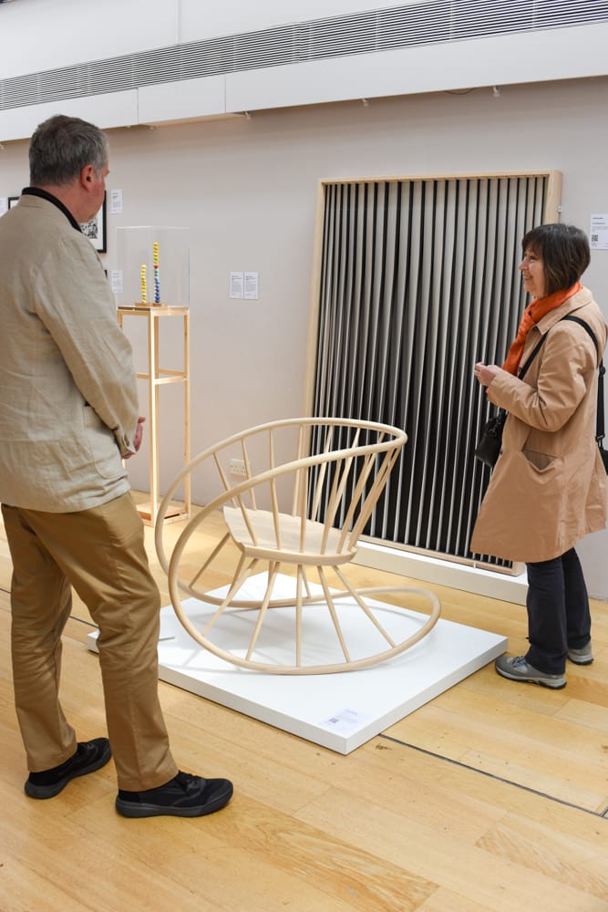 People admiring a rocking chair by katie Walker